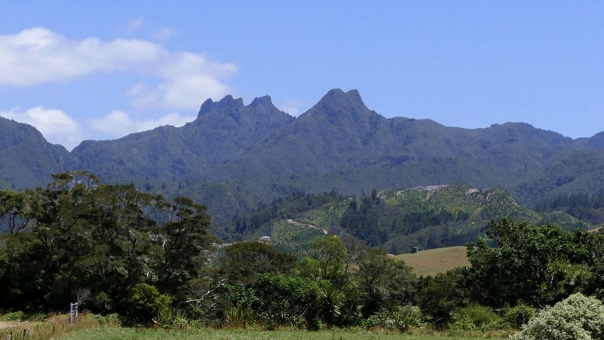 The jagged peaks of the Pinnacles rising above farmland and native bush in the Coromandel Range